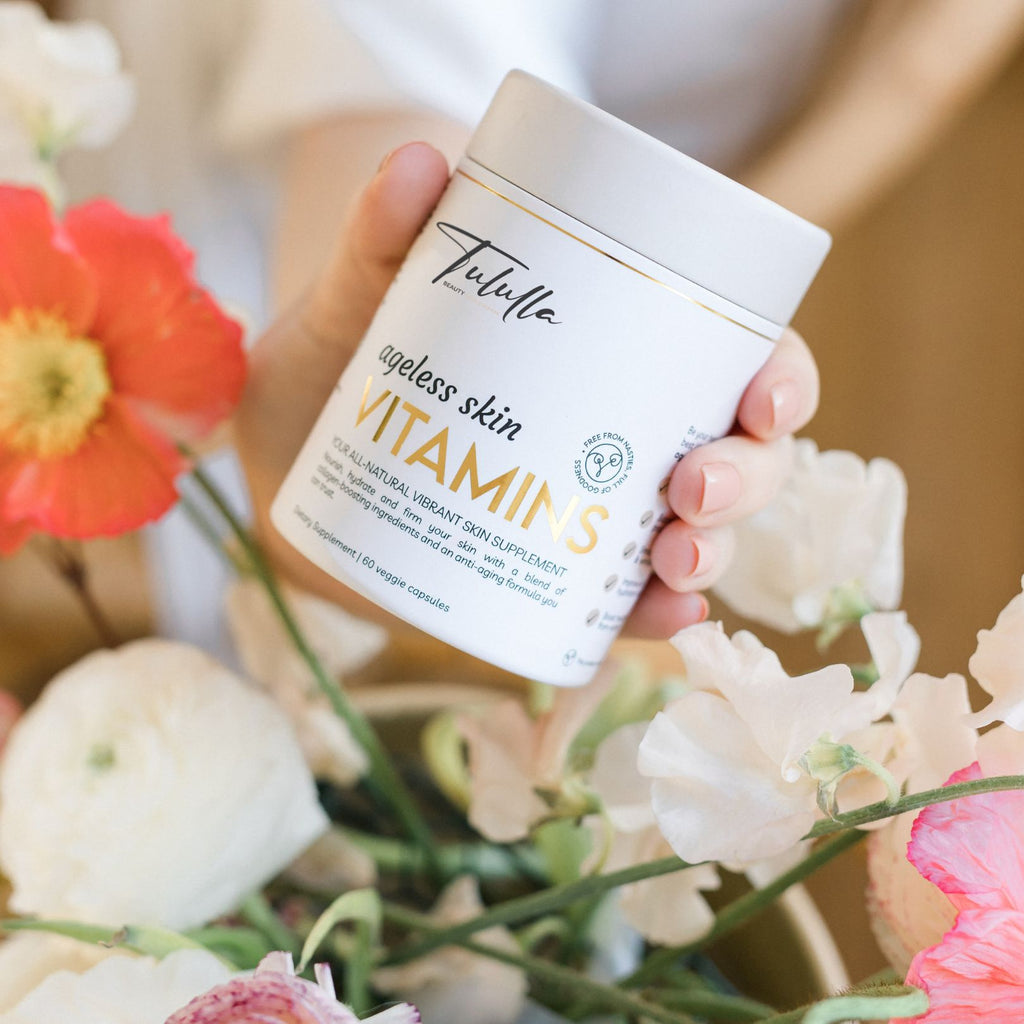 Ageless Skin Vitamins plastic free packaging in the hands of a beautiful women amongst flowers.